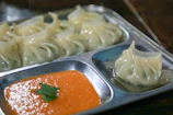 Golden crispy fried momos served with tangy orange and black dipping sauce.