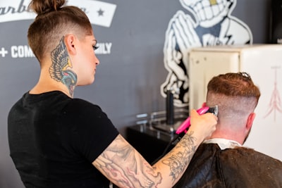 man in black crew neck t-shirt holding purple and white hair brush trimming teams background