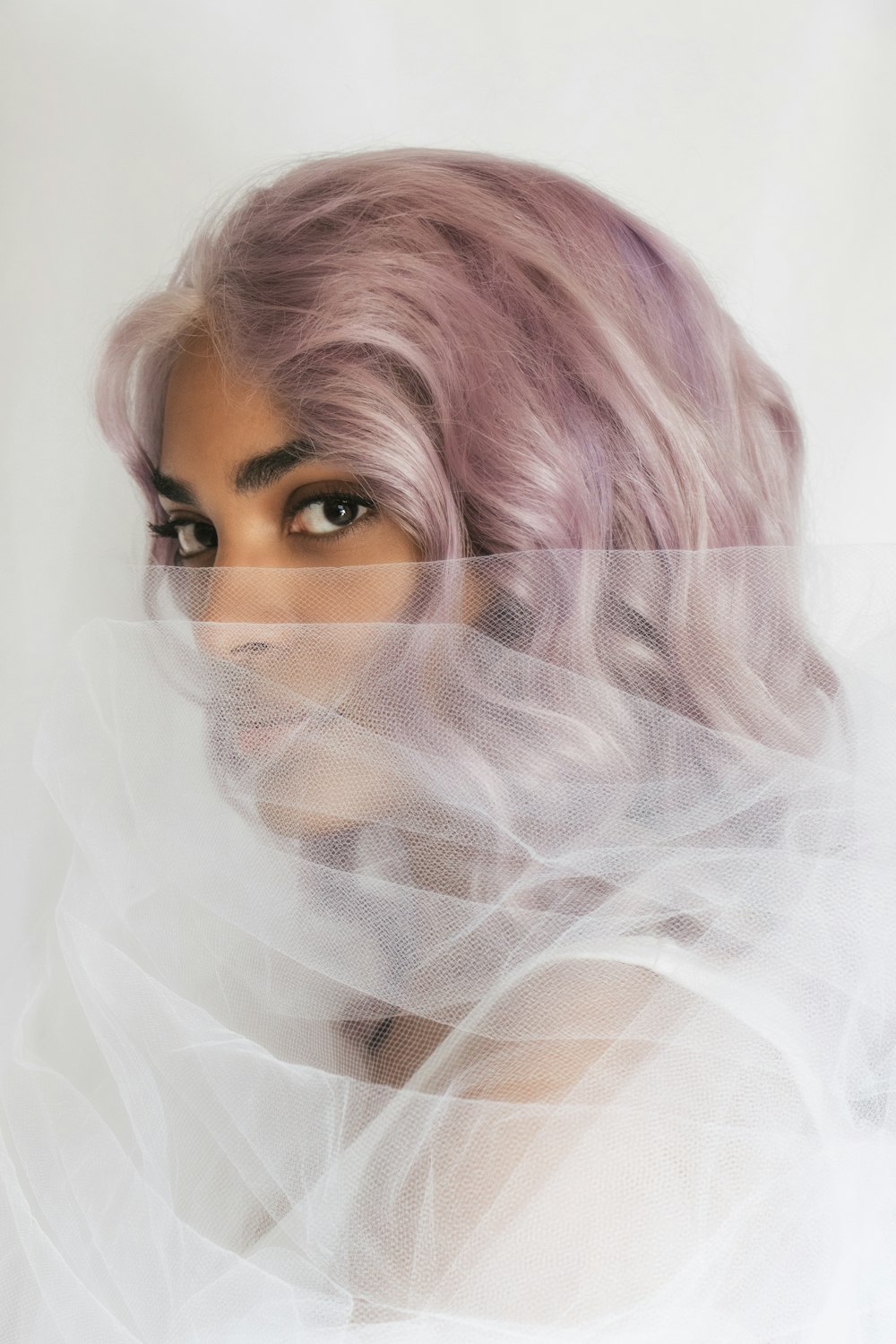 woman in white veil covering her face