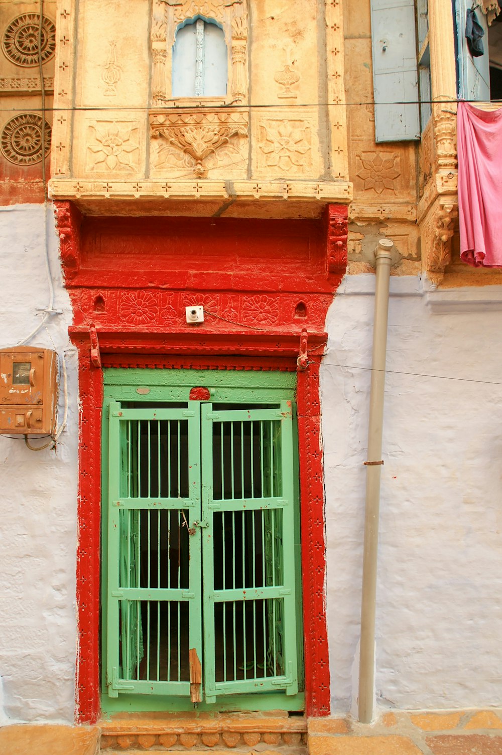 緑色のスチール製ドアレバー付き赤い木製ドア