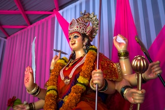 woman in red and gold traditional dress holding stick