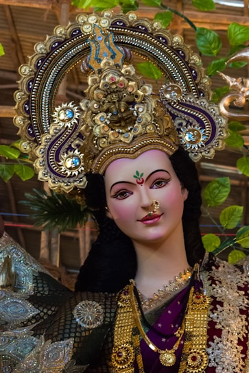 woman in blue and gold floral dress wearing gold crown