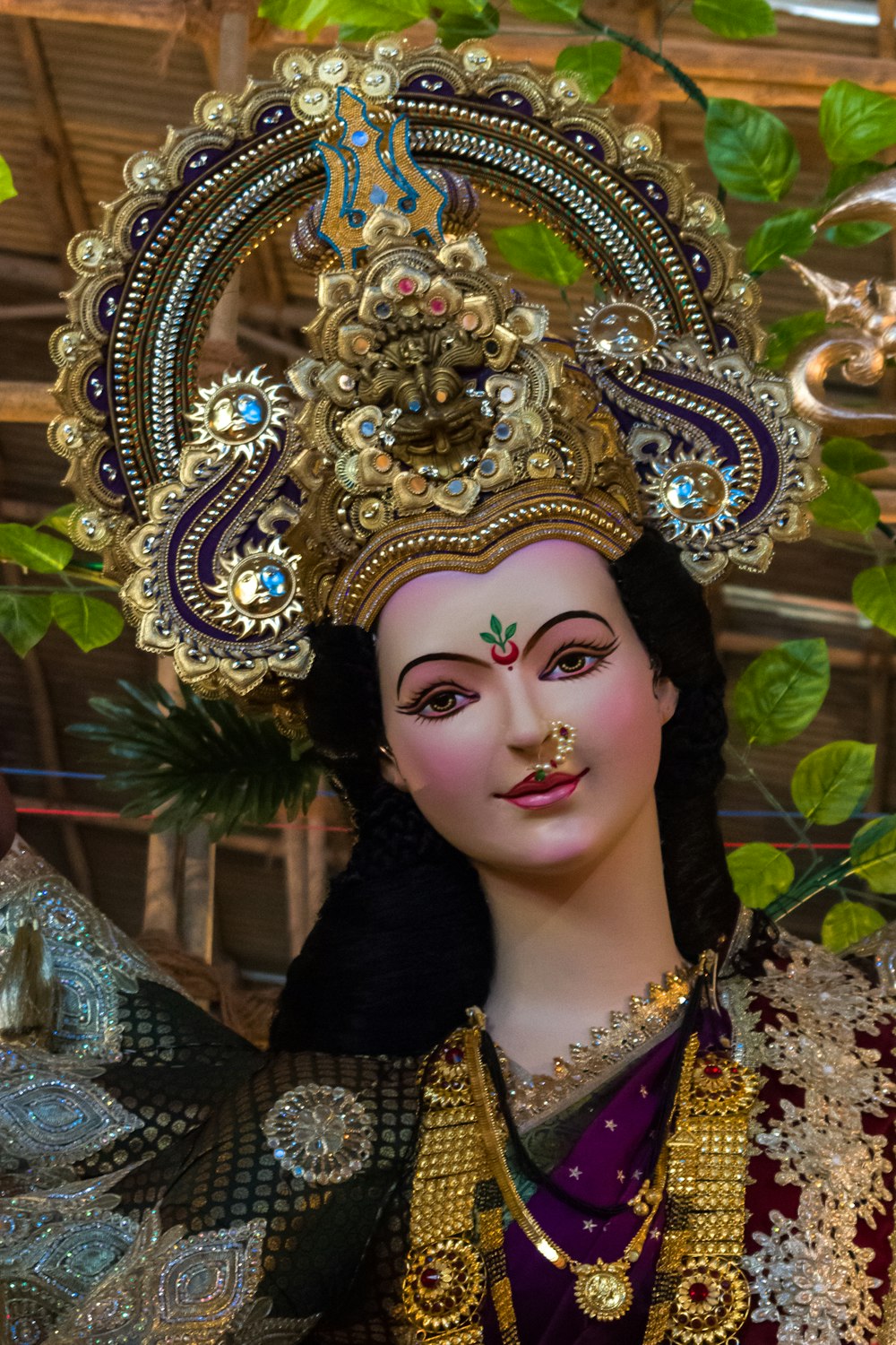 woman in blue and gold floral dress wearing gold crown