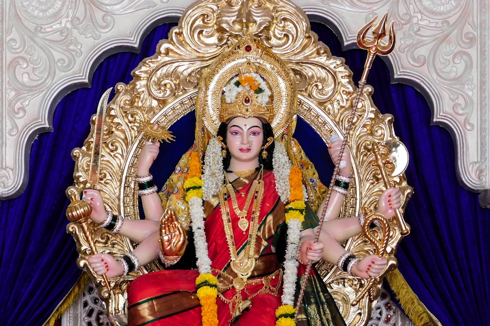 Estatueta de divindade hindu dourada e vermelha