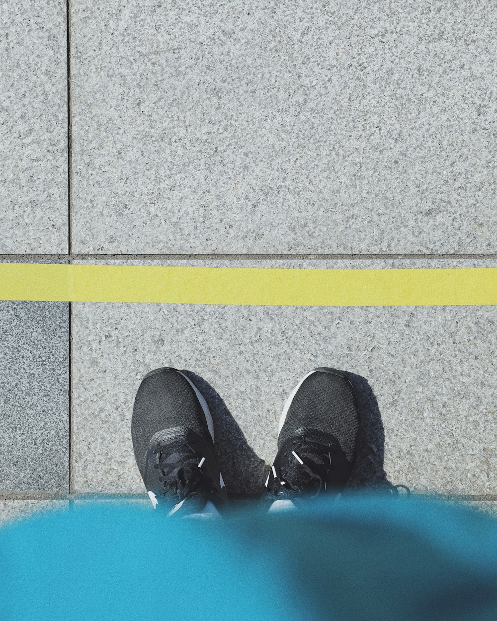 person in black shoes standing on gray concrete floor