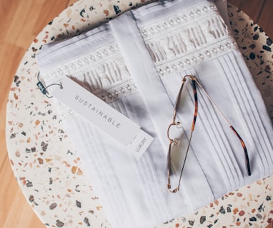 silver framed eyeglasses on white and blue floral textile