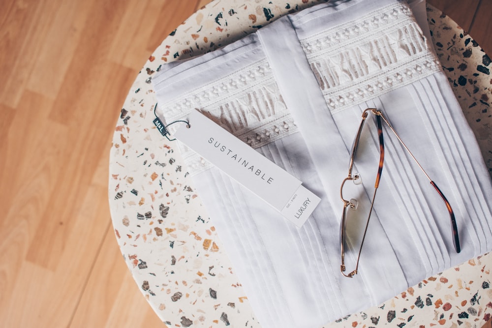 Gafas graduadas con montura plateada sobre textil floral blanco y azul