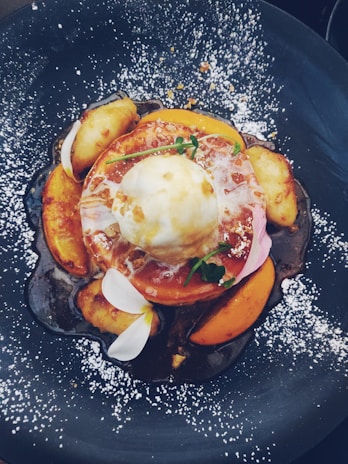 A beautifully plated dessert with fresh fruit and cream.