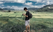 man in black jacket and white shorts standing on green grass field during daytime