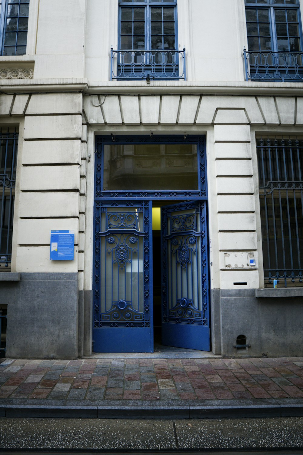 白いコンクリートの建物に青い木製のドア