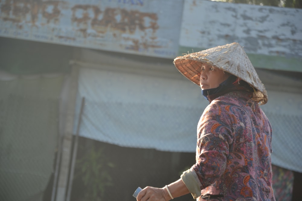 woman in brown and white floral long sleeve shirt wearing brown straw hat