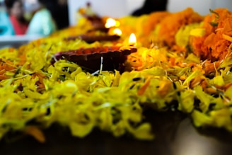 A warm, inviting photo of traditional pooja items arranged on a brass plate with marigold flowers.
