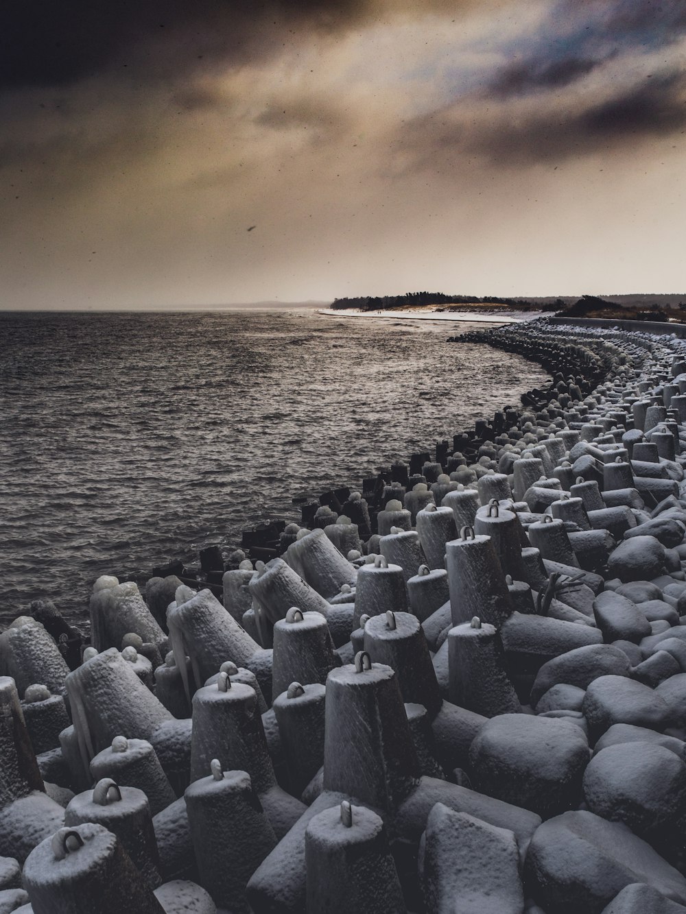 gray concrete blocks on seashore during sunset