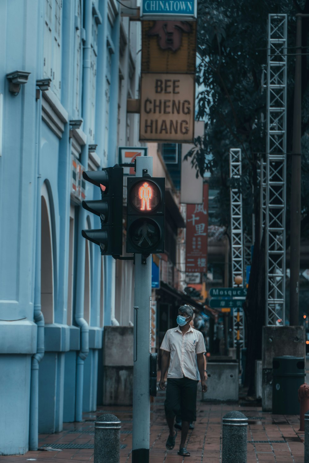 man in white dress shirt and black pants standing near traffic light during daytime