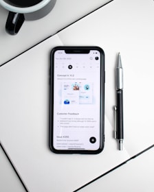 A modern notebook open on a desk with a cup of coffee and a smartphone beside it.