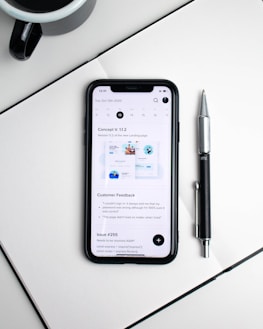 A digital calendar open on a tablet next to a cup of coffee and a pen.