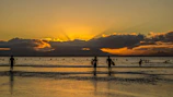 A stunning sunset over Kedungu Beach with surfers silhouetted on their boards.