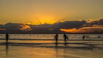 A stunning sunset over Kedungu Beach with surfers silhouetted on their boards.