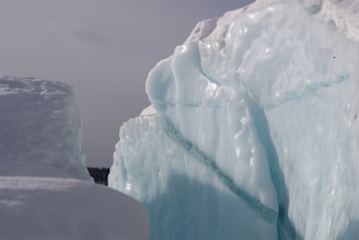 A serene scene of a frozen glacier with deep blue ice formations glowing softly against a dark background.