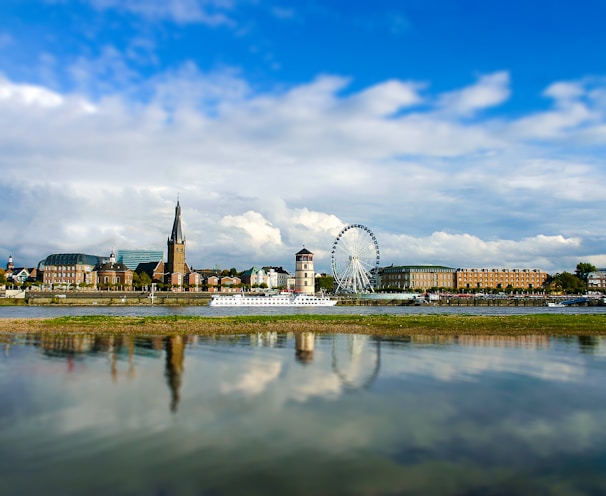 white ferris wheel near body of water under blue sky during daytime