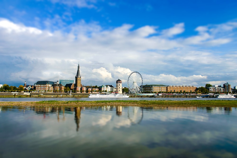 white ferris wheel near body of water under blue sky during daytime