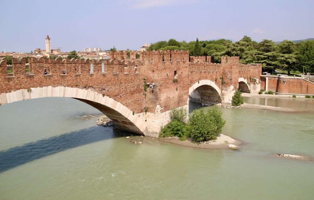 brown concrete bridge over river during daytime