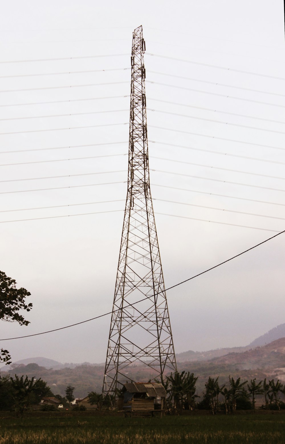 black electric tower near trees during daytime