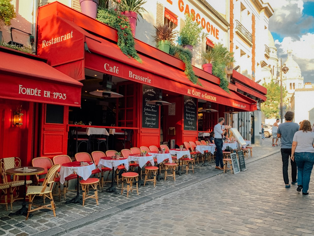 people sitting on chair near red building during daytime