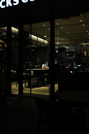 A serene coffee shop setting with a person working on a laptop.