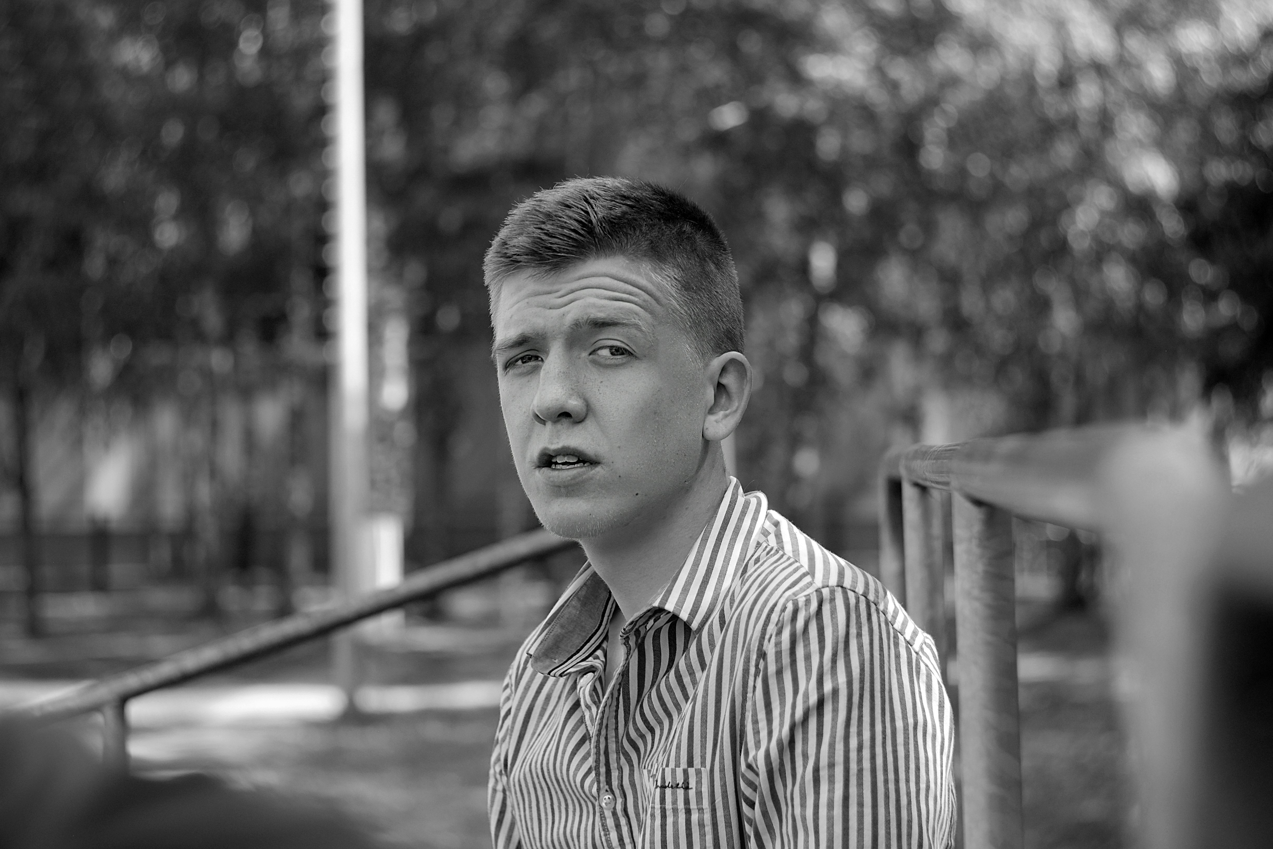 grayscale photo of man in striped dress shirt
