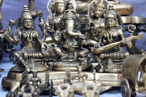 A collection of brass murtis arranged beautifully for gifting, wrapped in traditional fabric.
