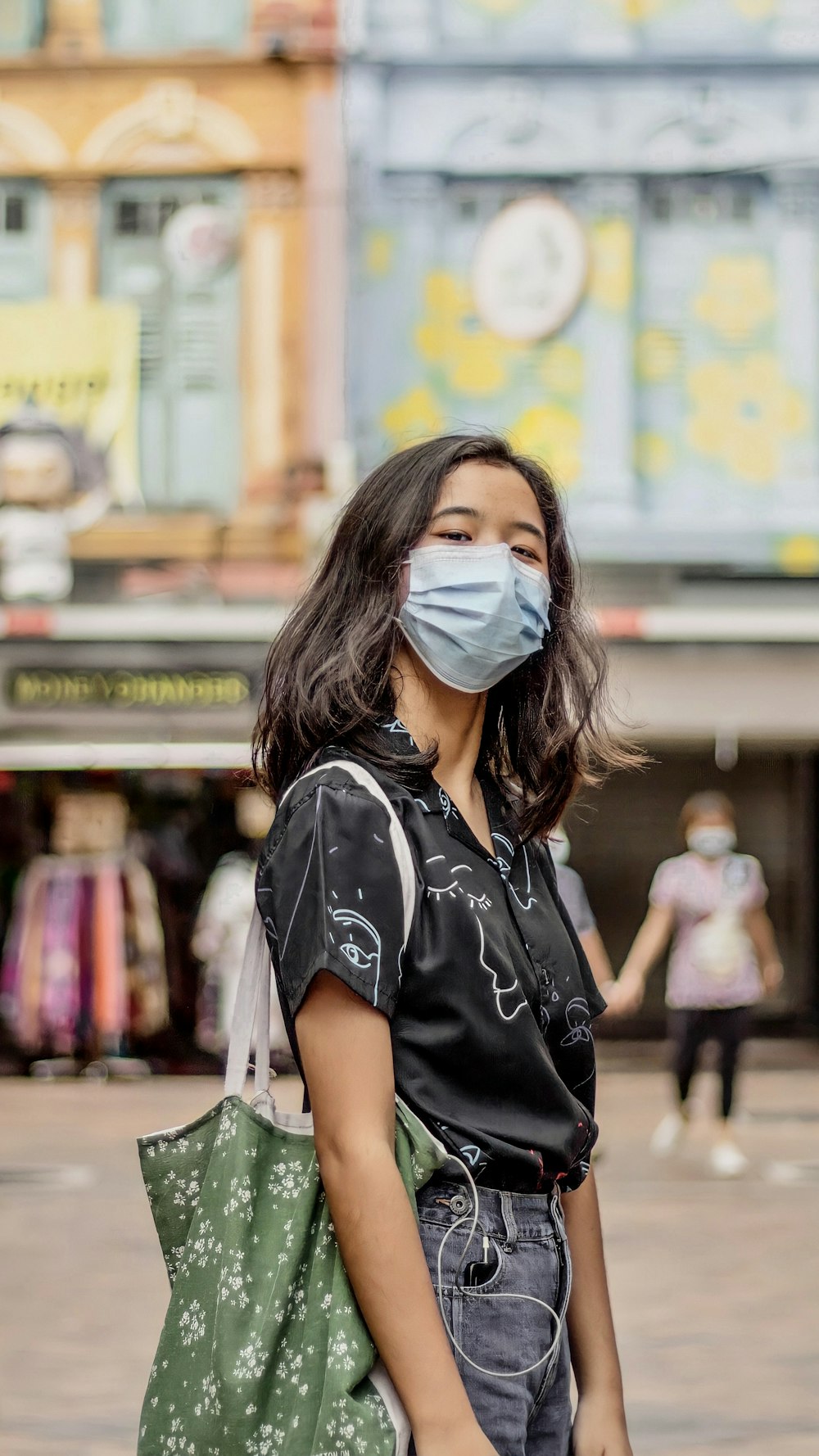 woman in black and white shirt wearing white mask