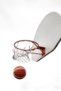 Basketball hoop with ball mid-air during a game.