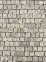 Workers laying cobblestones for a durable and aesthetic driveway surface.