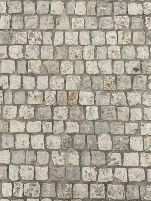 Workers laying cobblestones for a durable and aesthetic driveway surface.