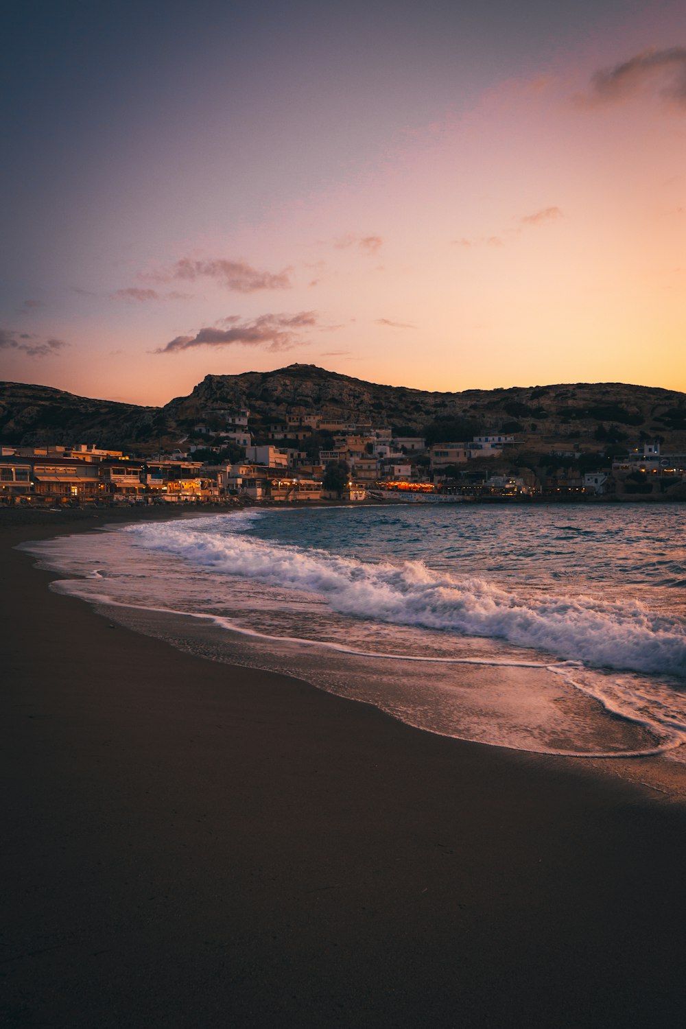 sea waves crashing on shore during sunset