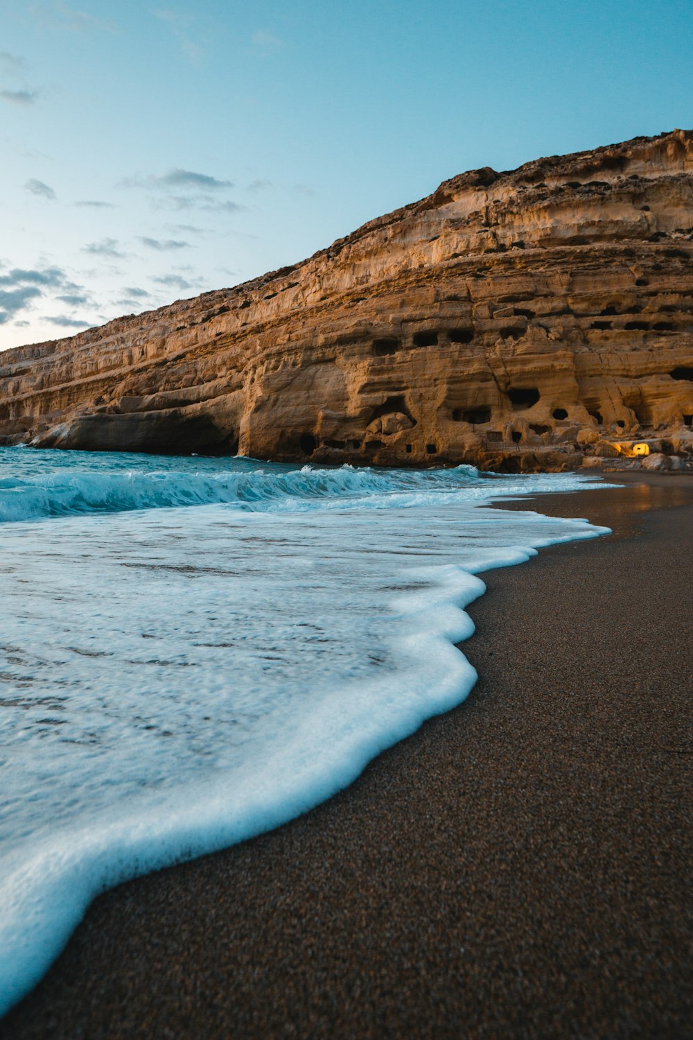 brown rock formation near body of water during daytime