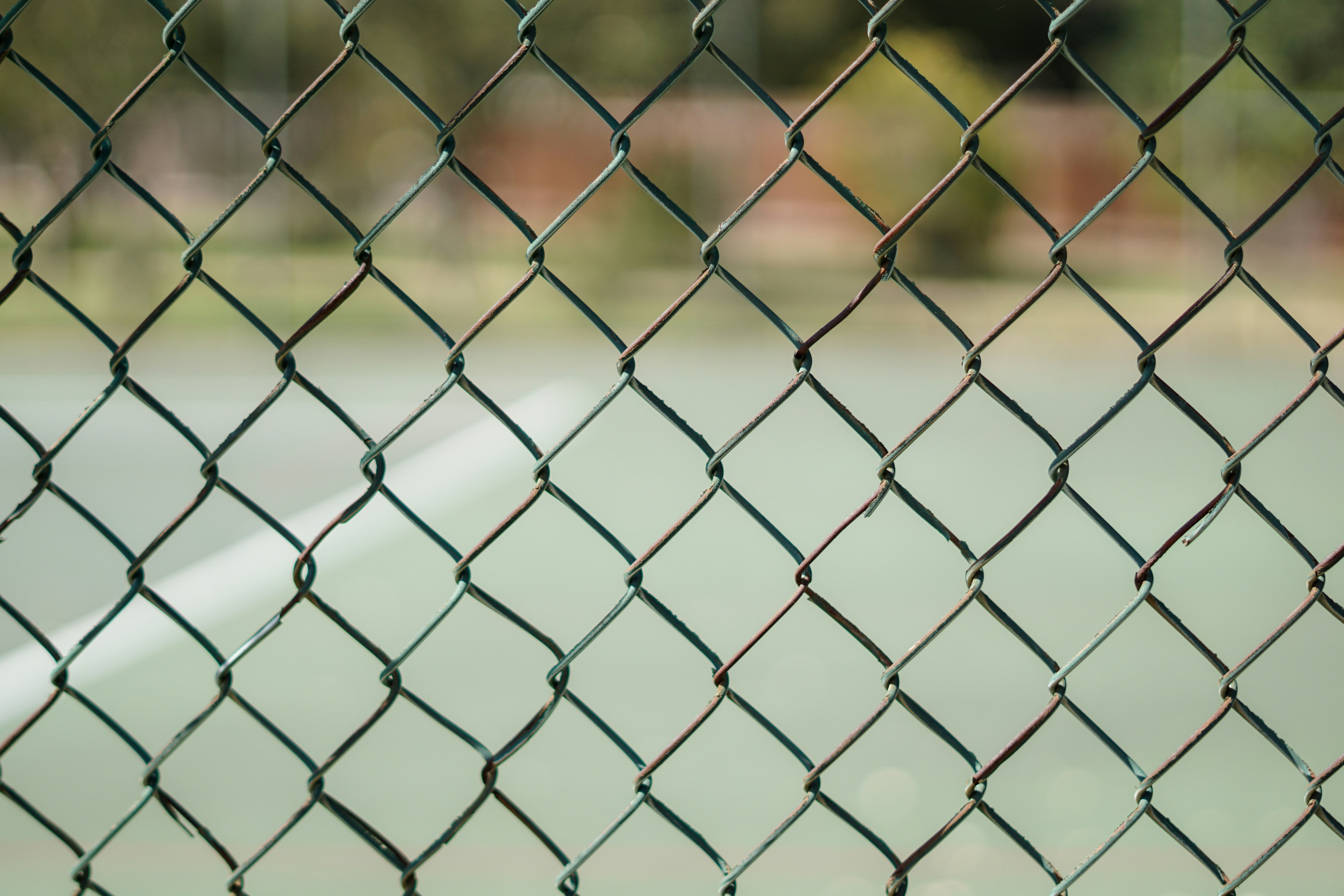 A fence in front of a tennis court.