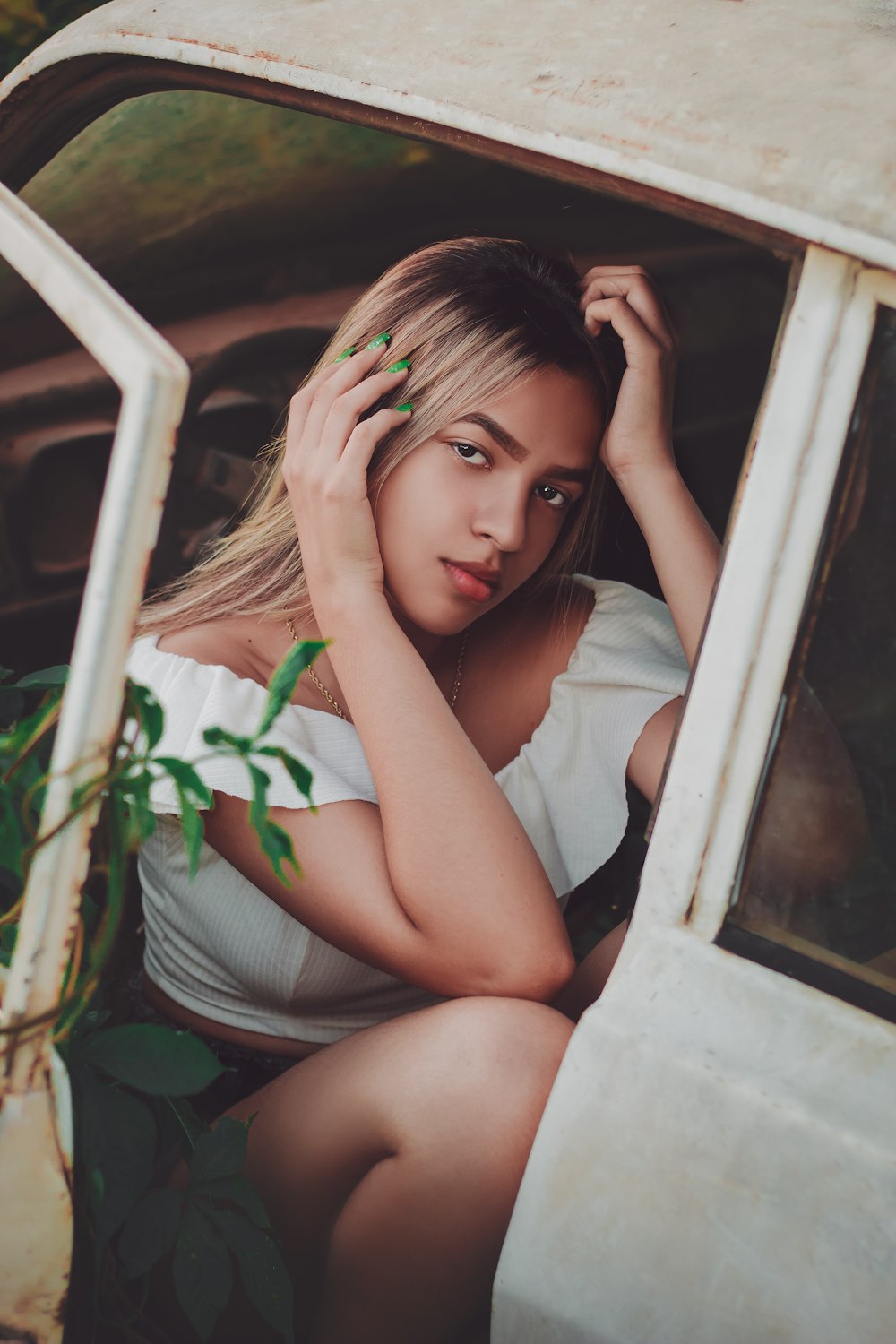 woman in white tank top sitting on window