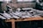 A close-up of rugged tools arranged on a wooden workbench in a workshop setting.