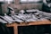 A close-up of rugged tools arranged on a wooden workbench in a workshop setting.