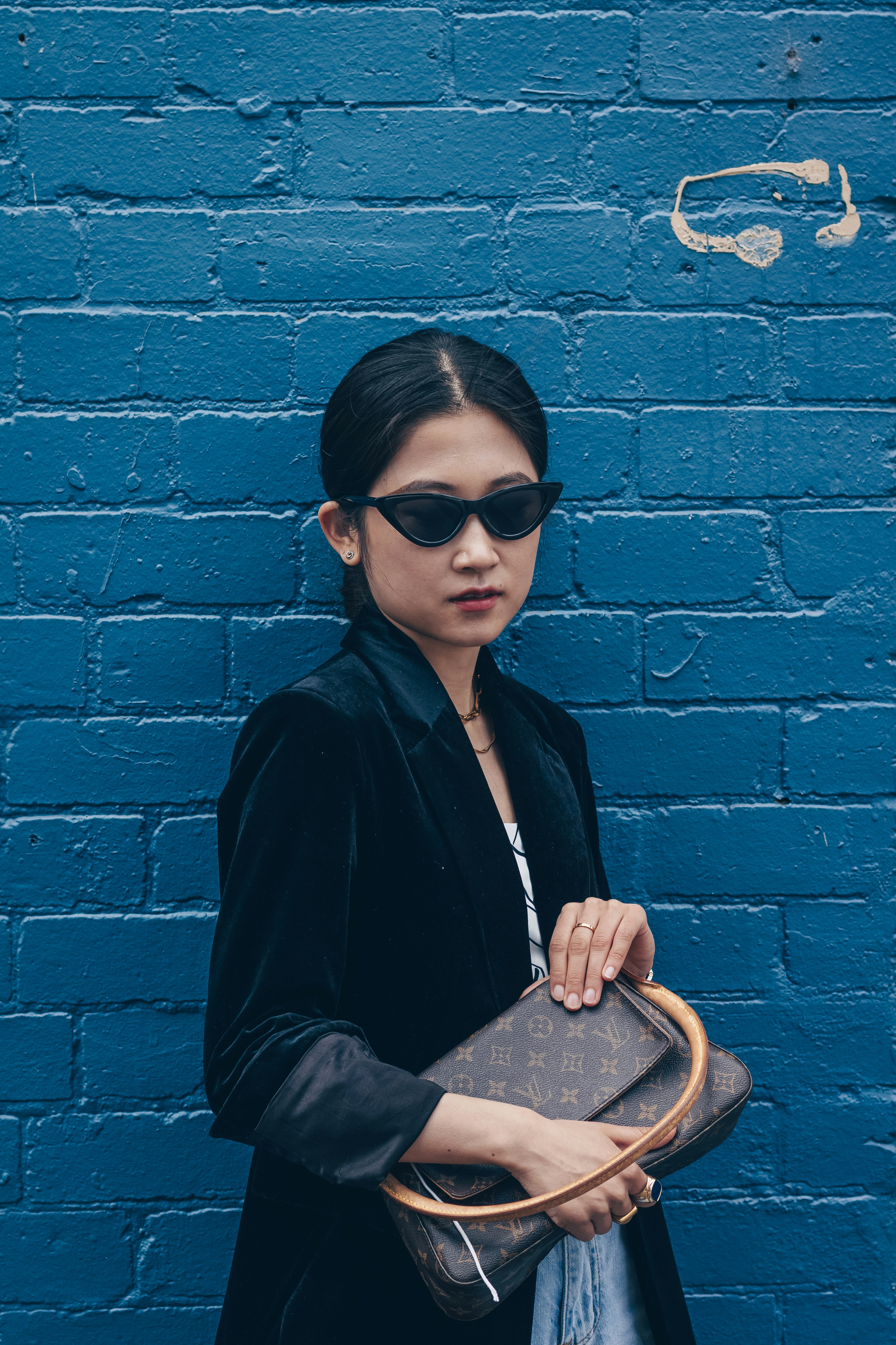 woman in black blazer and black sunglasses sitting on bench