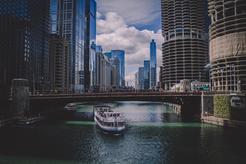 white and blue boat on water near city buildings during daytime