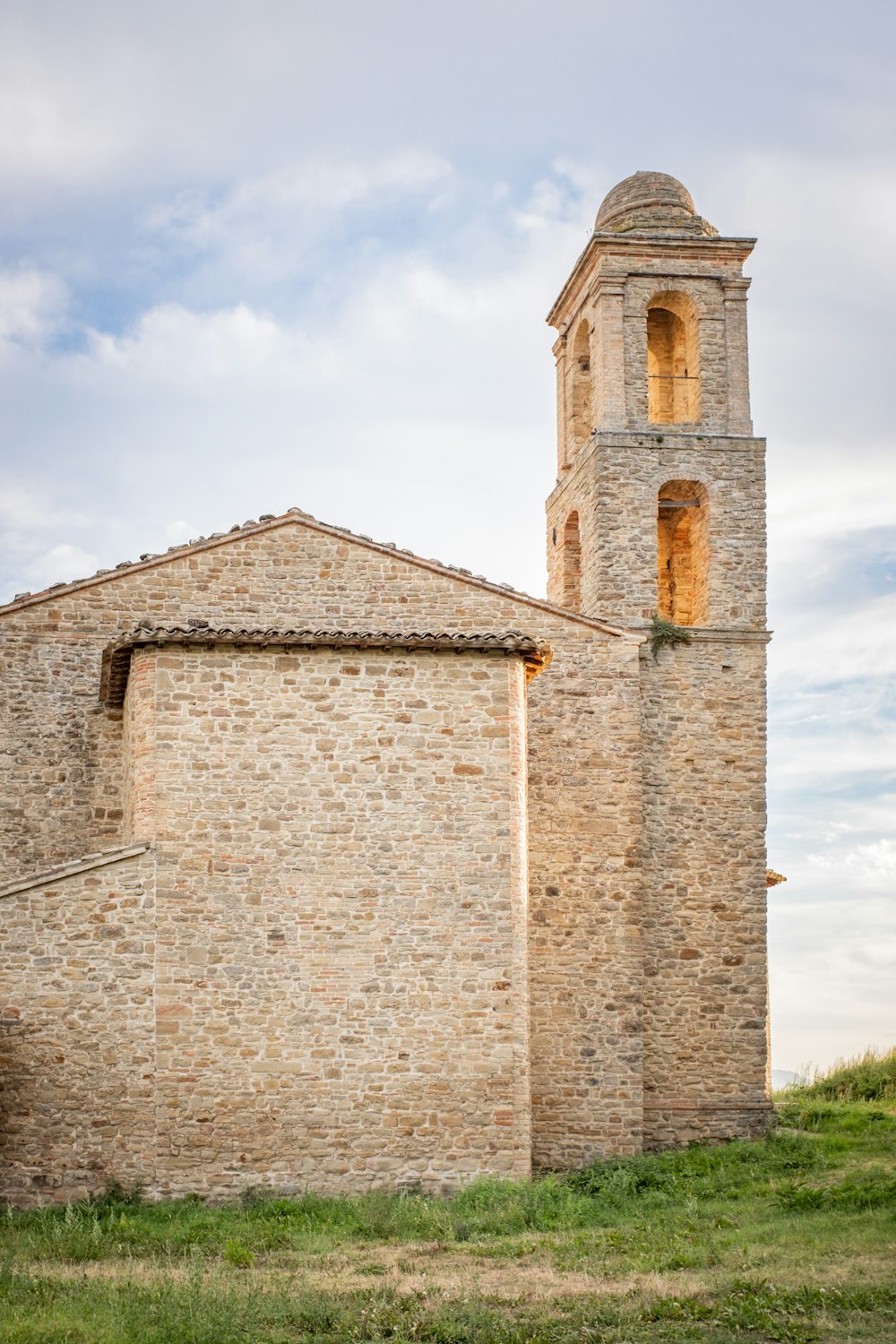 brown brick building under white clouds during daytime