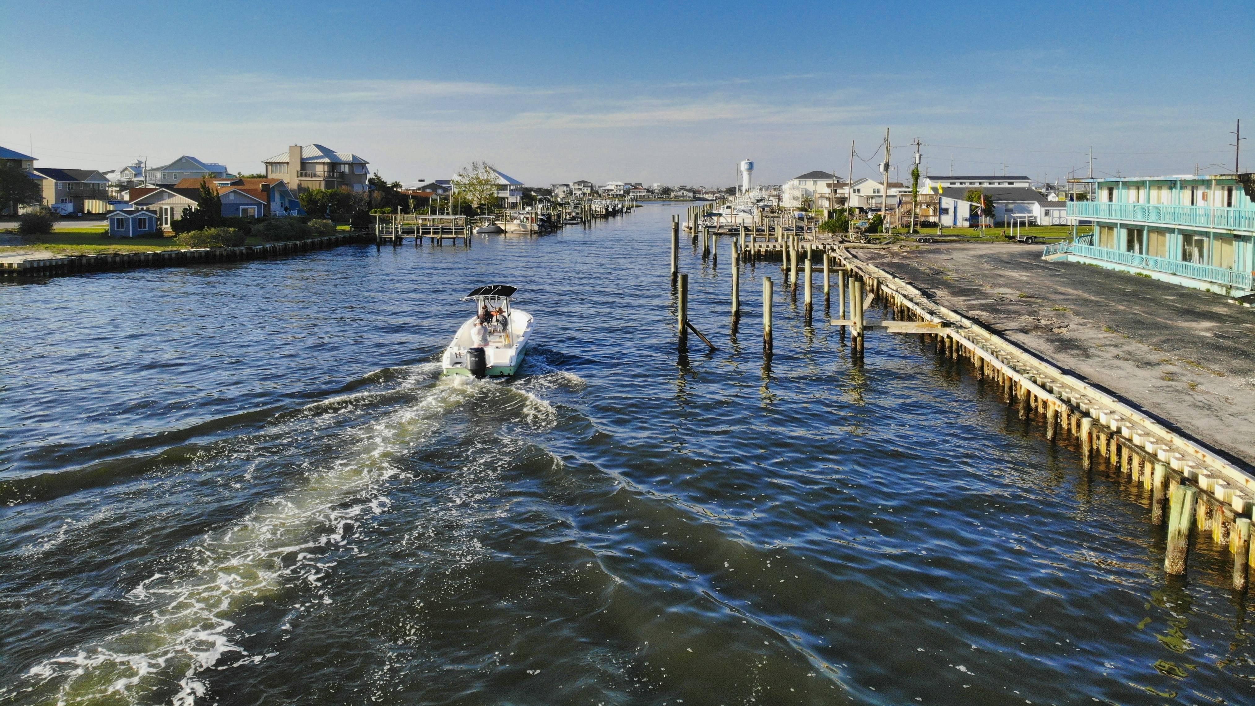 woman in white shirt sitting on wooden dock during daytime