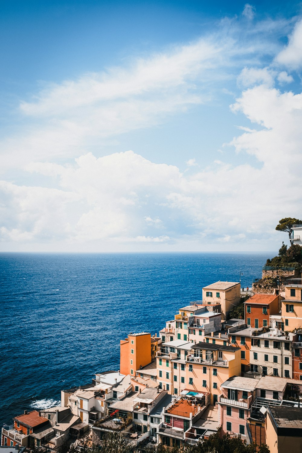 city buildings near sea under white clouds during daytime