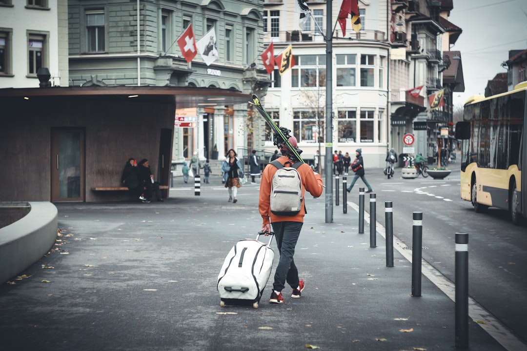 man in orange jacket and black pants with white helmet riding on white and black motor, Lonely traveller