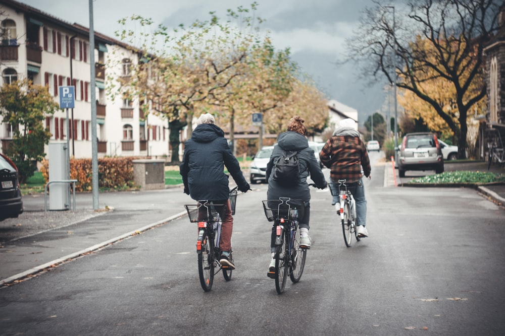 people riding on bicycles on road during daytime