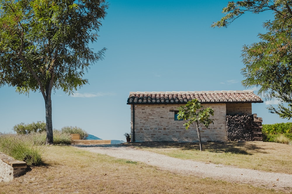 Maison en briques brunes près des arbres verts sous le ciel bleu pendant la journée