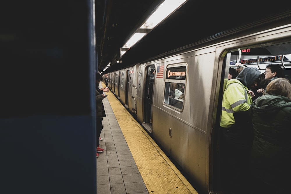 man in black jacket standing beside train